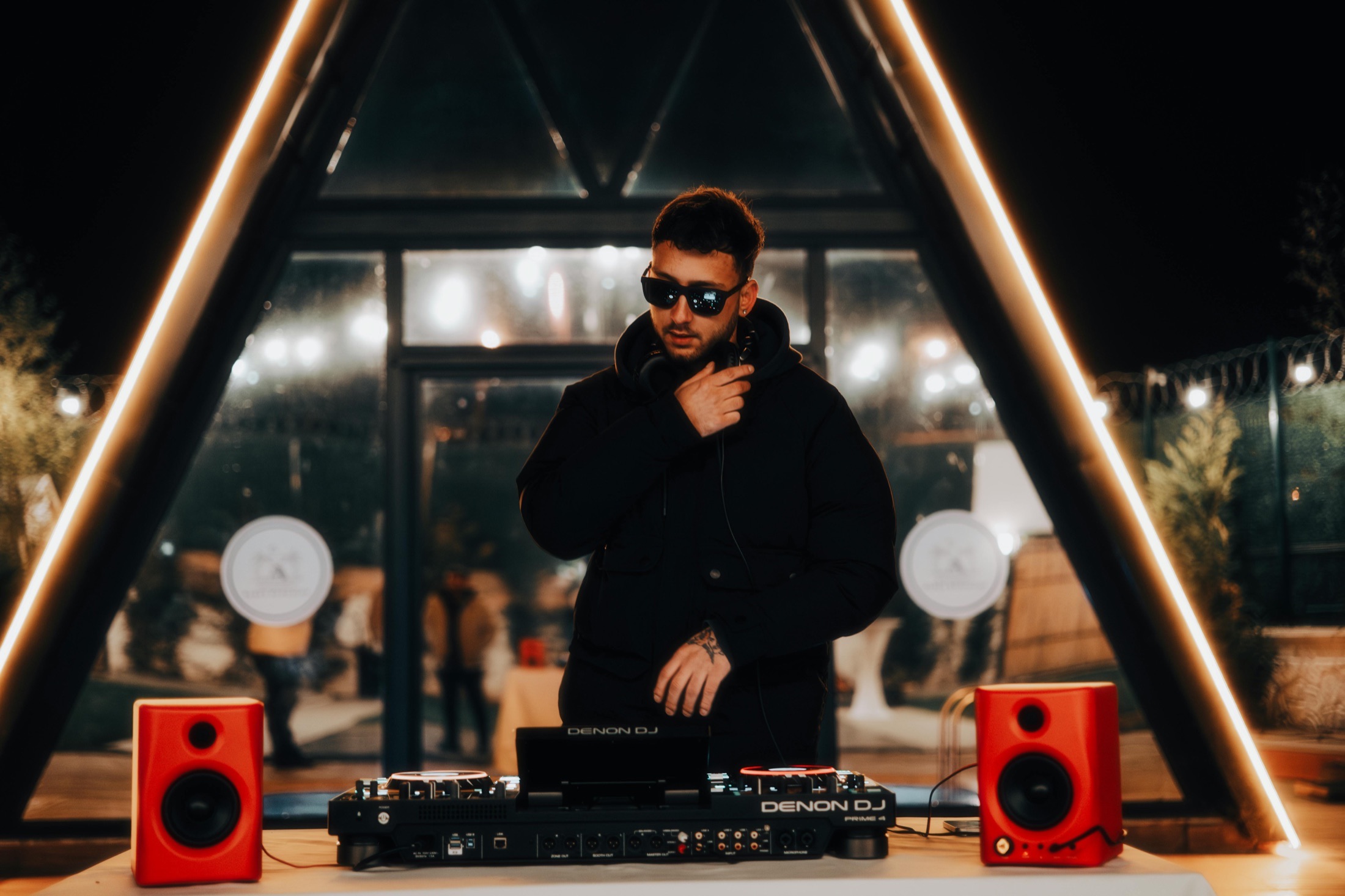 DJ standing behind equipment under warm lights